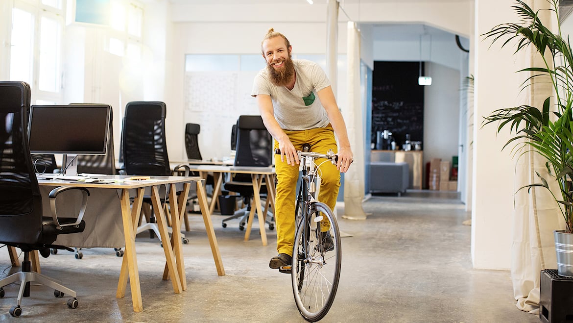 Man på cykel i  kontorslandskap